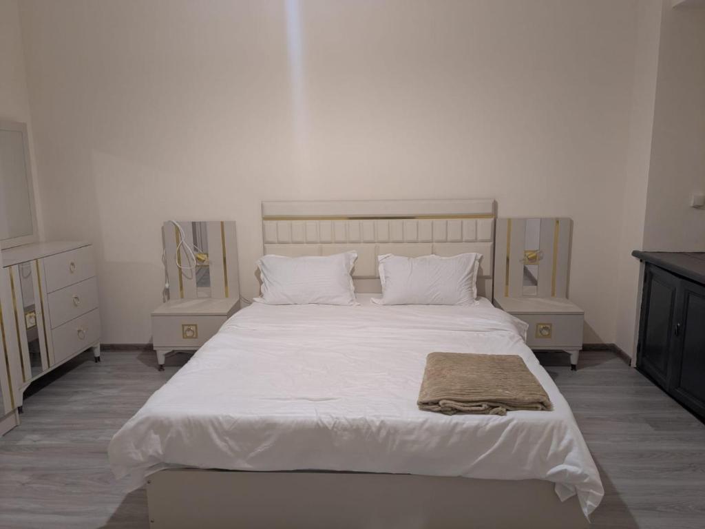 a bedroom with a large bed with white sheets and pillows at Parkside Residences in Tbilisi City