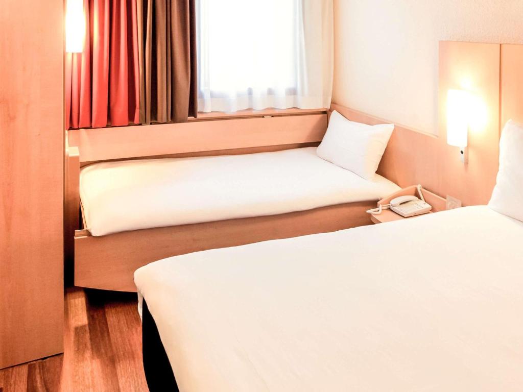 a hotel room with two beds and a window at ibis Lyon Gare Part Dieu in Lyon