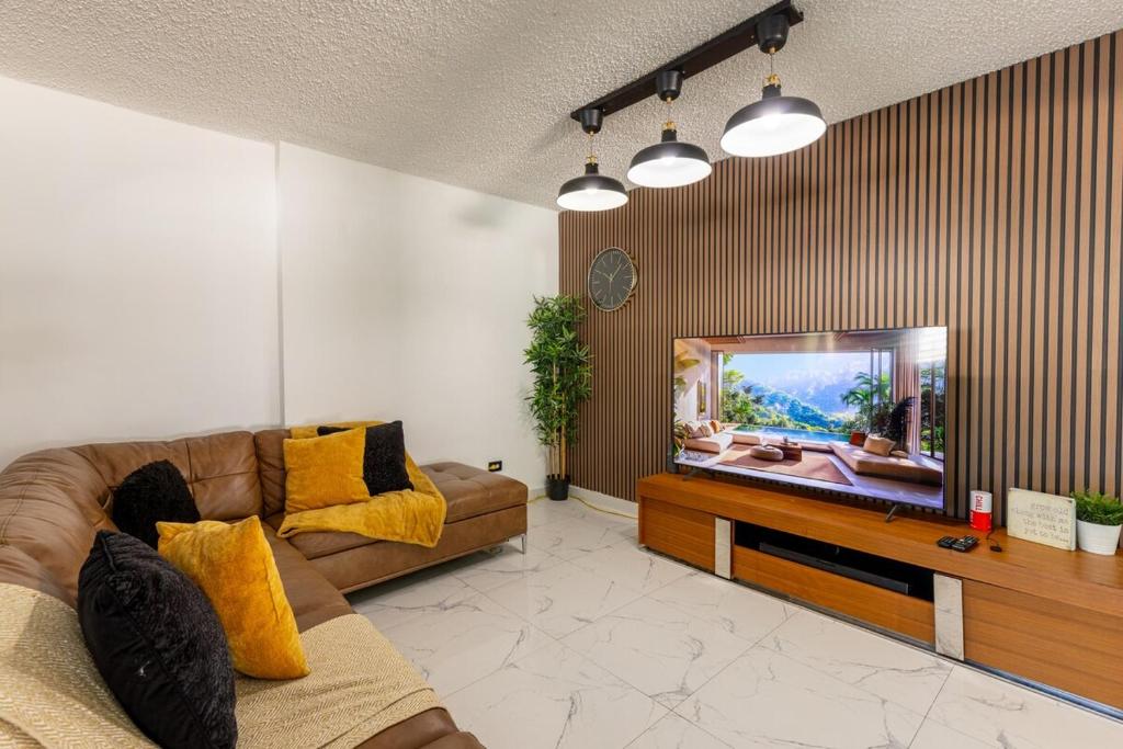 un salon avec un canapé et une télévision à écran plat dans l'établissement Dorado White House 6BR Family & Corporate Villa, à Dorado