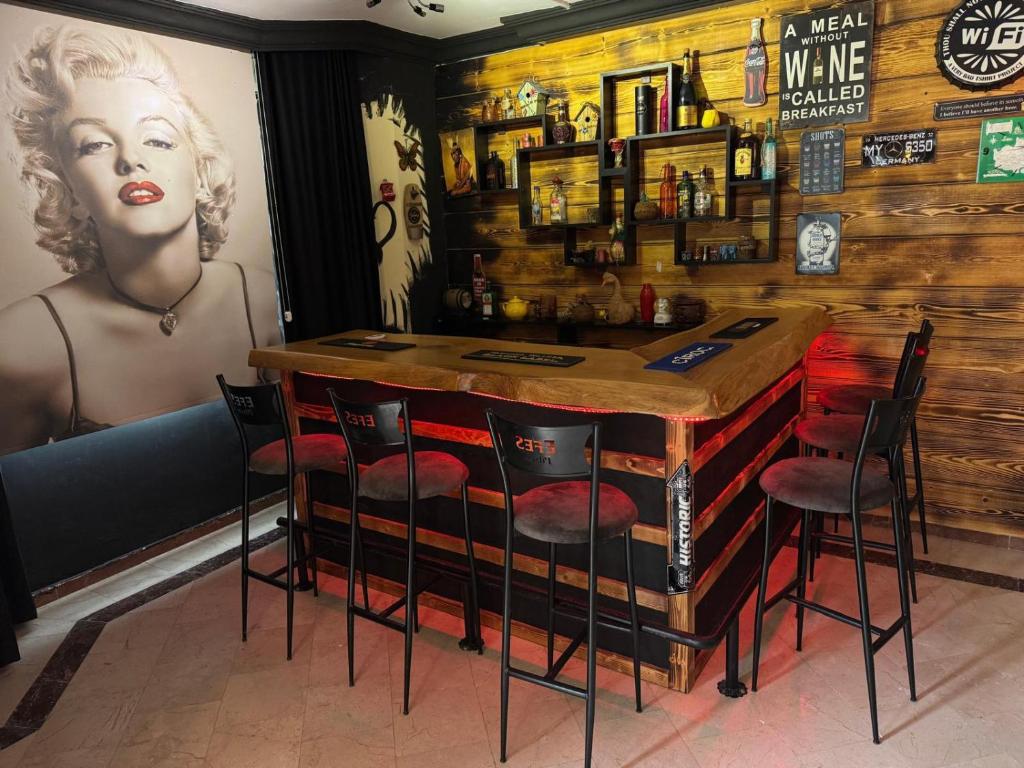 a bar with red chairs and a wooden wall at ViLLA GREEN in Kérynia