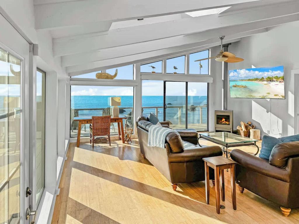 a living room with leather furniture and a view of the ocean at Seaside Elegance Oceanfront Escape with 3 Suites in Carmet
