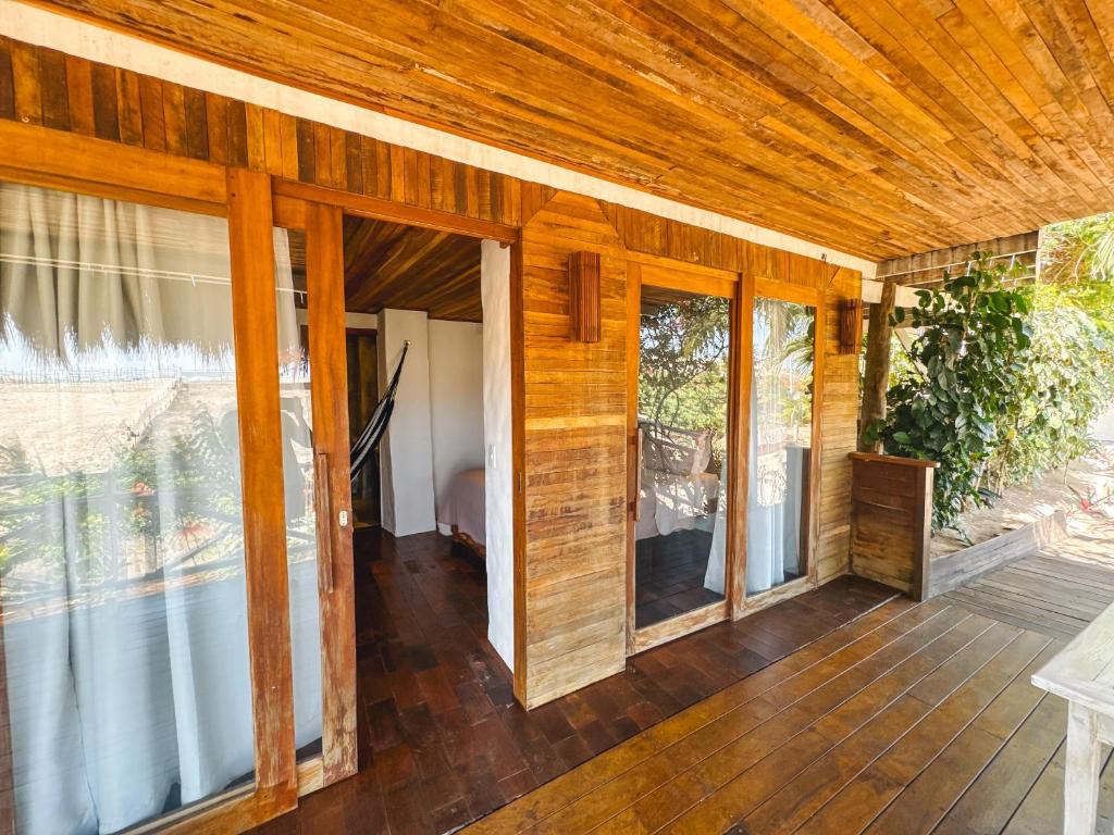Habitación con puertas correderas de cristal en una casa en Pousada Dunnas Moitas, en Amontada