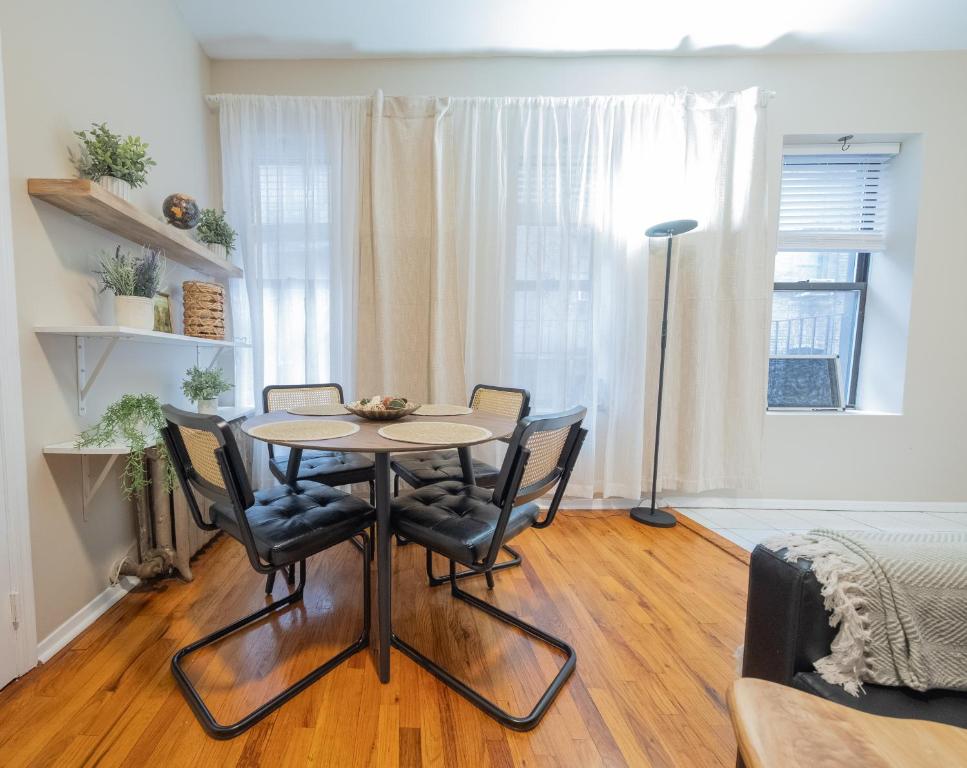 une salle à manger avec une table et quatre chaises dans l'établissement Spacious 3BR Near Columbia Uni & Riverside Park, à New York