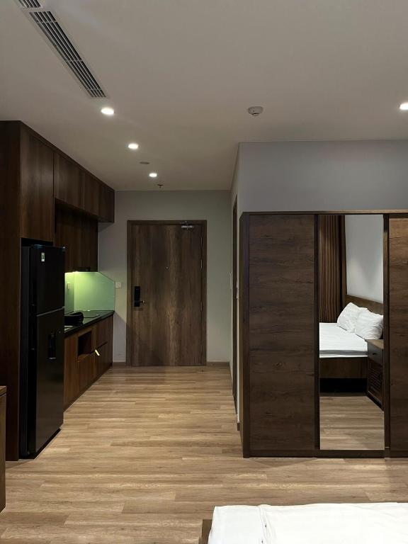 a room with a kitchen with a bed and a refrigerator at Oak Room Ở Space Ecopark in Kim Quan