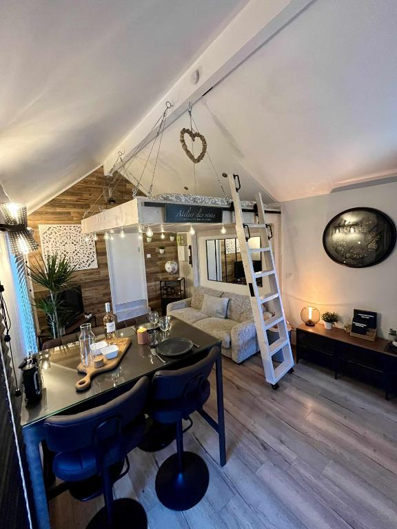 a living room with a table and a loft bed at Le Perchoir " Une nuit suspendu dans le temps" in Chessy