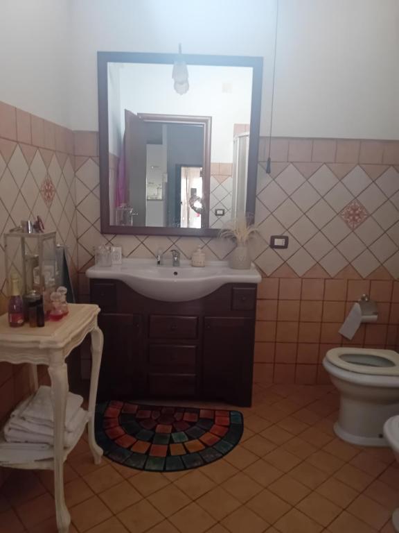 a bathroom with a sink and a mirror and a toilet at Villa Eden in Porto Empedocle