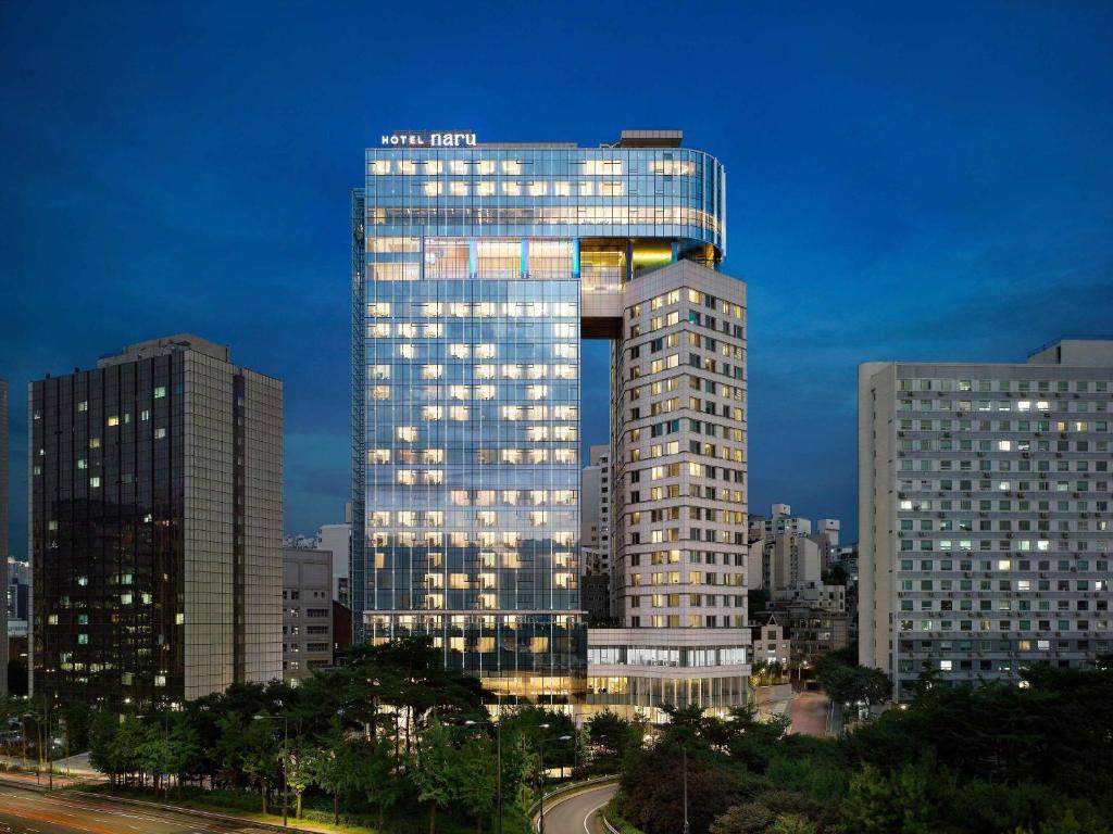 a tall building with lights on in a city at Naru Ambassador Hotel Seoul - MGallery Collection in Seoul