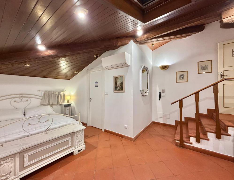a bedroom with a white bed and a wooden ceiling at Villa Meraville in Bologna