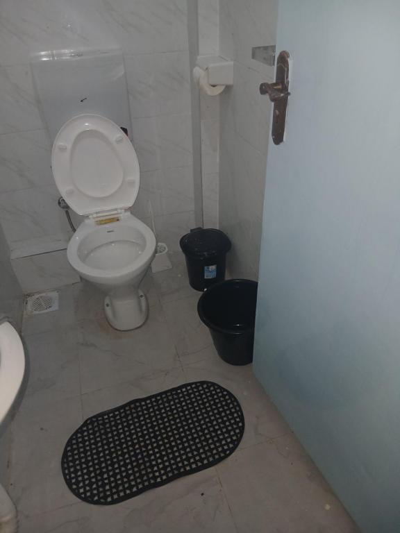 bagno con servizi igienici e tappeto nero. di Abbey's bnb a Kikuyu