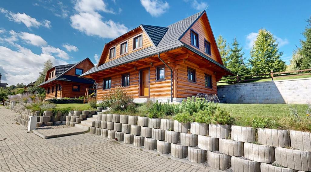 a wooden house with a fence in front of it at Roháčske zruby 2,3,4 in Zuberec