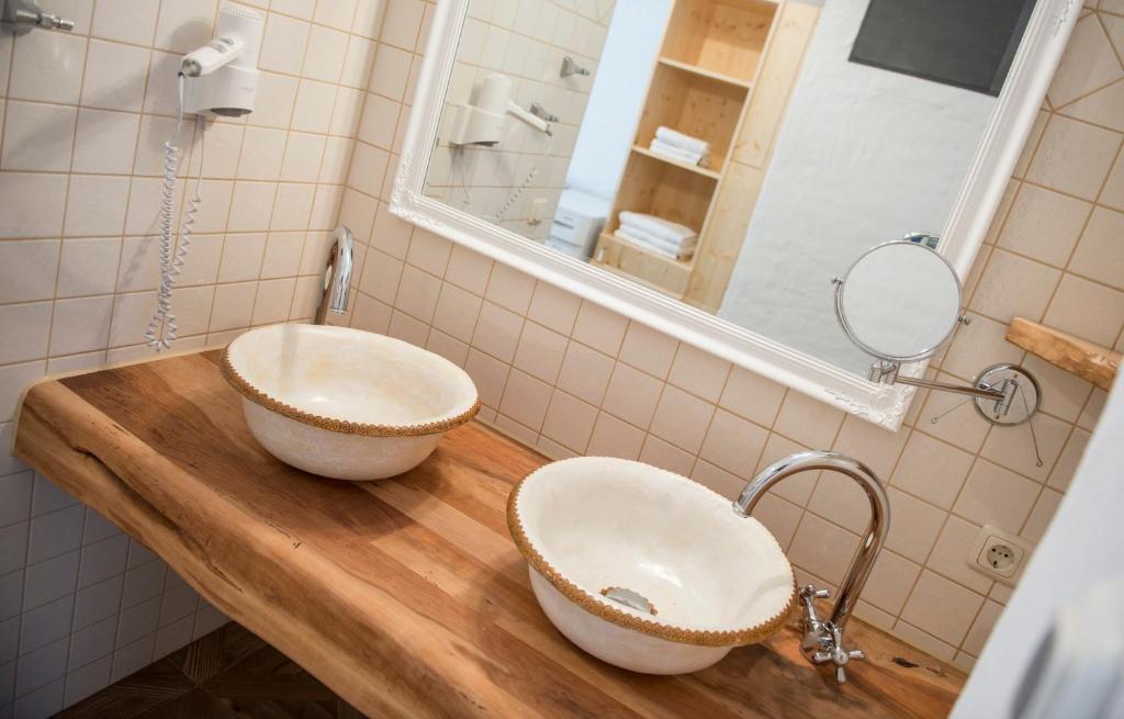 ein Badezimmer mit zwei Waschbecken auf einer Holztheke in der Unterkunft Salzhaus in Hallstatt