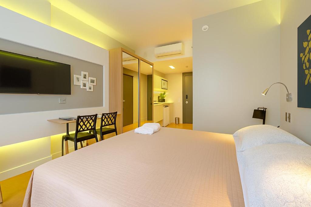 a hotel room with two beds and a flat screen tv at 1164 Helbor Stay Batel, Conforto e Estilo no Coração de Curitiba in Curitiba