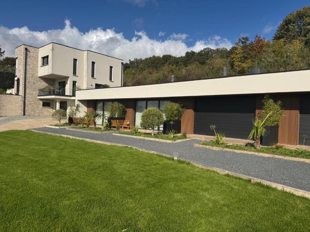 a house with a green lawn in front of it at Le Domaine de la Vallée in Vernon