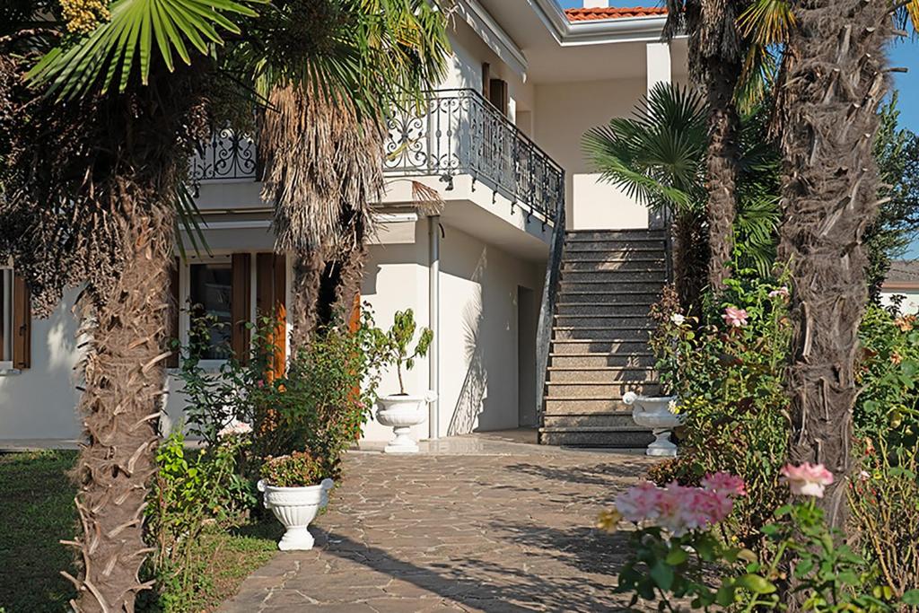Una casa con palmeras y escaleras y plantas. en Sybilvilla, en Oriago Di Mira