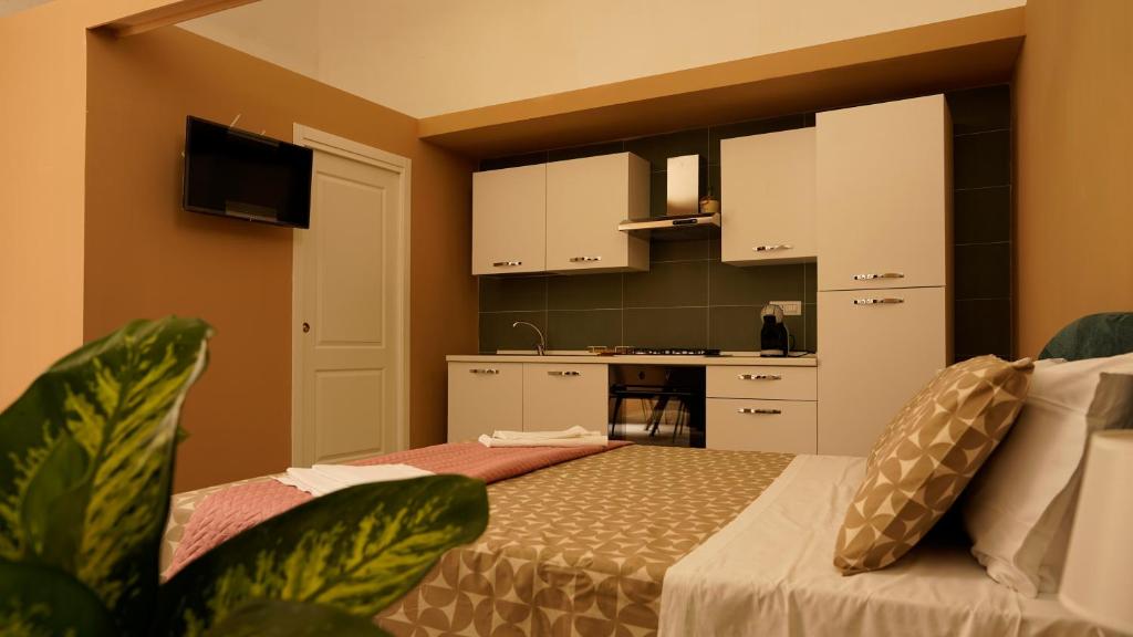 1 dormitorio con 1 cama y cocina en el fondo en Casa Vacanza Palazzo Monacelli, en Torre del Greco