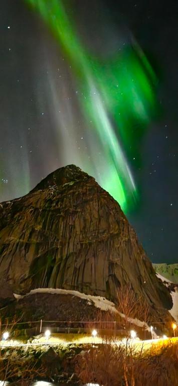 an image of a mountain with the aurora in the sky at Reinebringen View Apartment in Reine