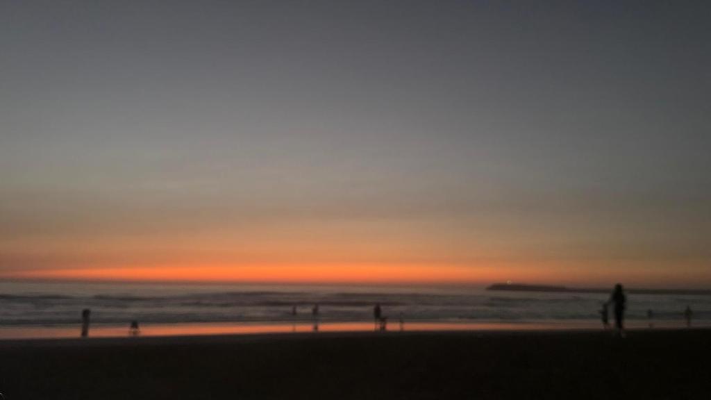 a group of people on the beach at sunset at bel appartement City à centre Mahdia in Kenitra