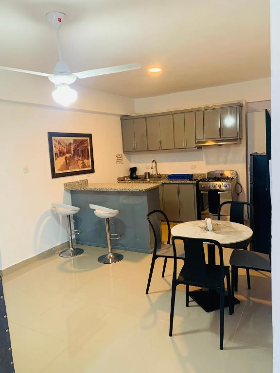 a kitchen with a table and chairs and a counter at Plataview Apartahotel 3B in Monte Plata