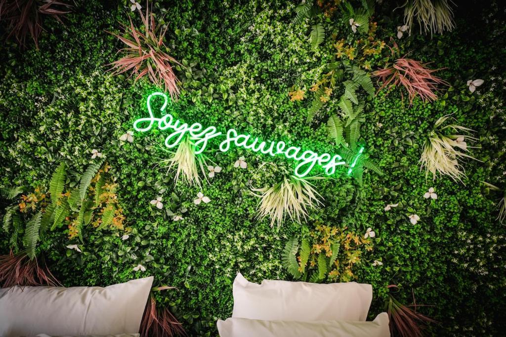 a green wall with a sign that reads ever blower at L'Amazone - Jungle Room avec Jacuzzi in Pont-du-Château