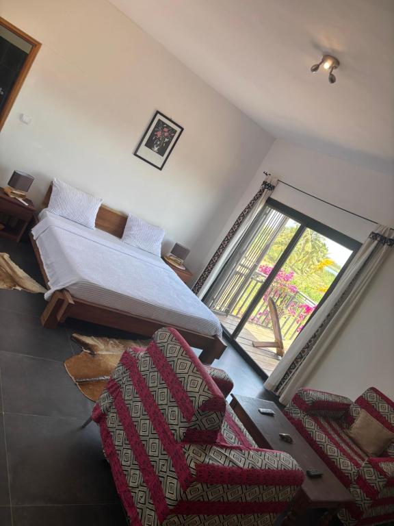 a room with two beds and a couch and a window at Chez Diarra in Saint-Louis