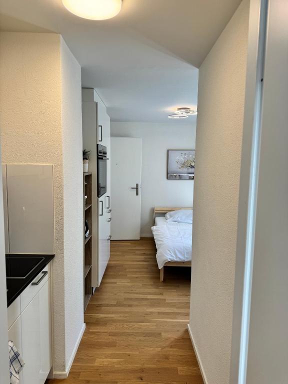 a hallway leading to a bedroom with a bed at Mc Solutions Apartment im Zentrum in St. Gallen