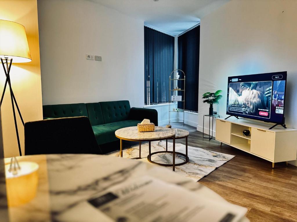Una sala de estar con un sofá y un televisor. en Royal Stay-Leeds City centre Apartment, en Central Station