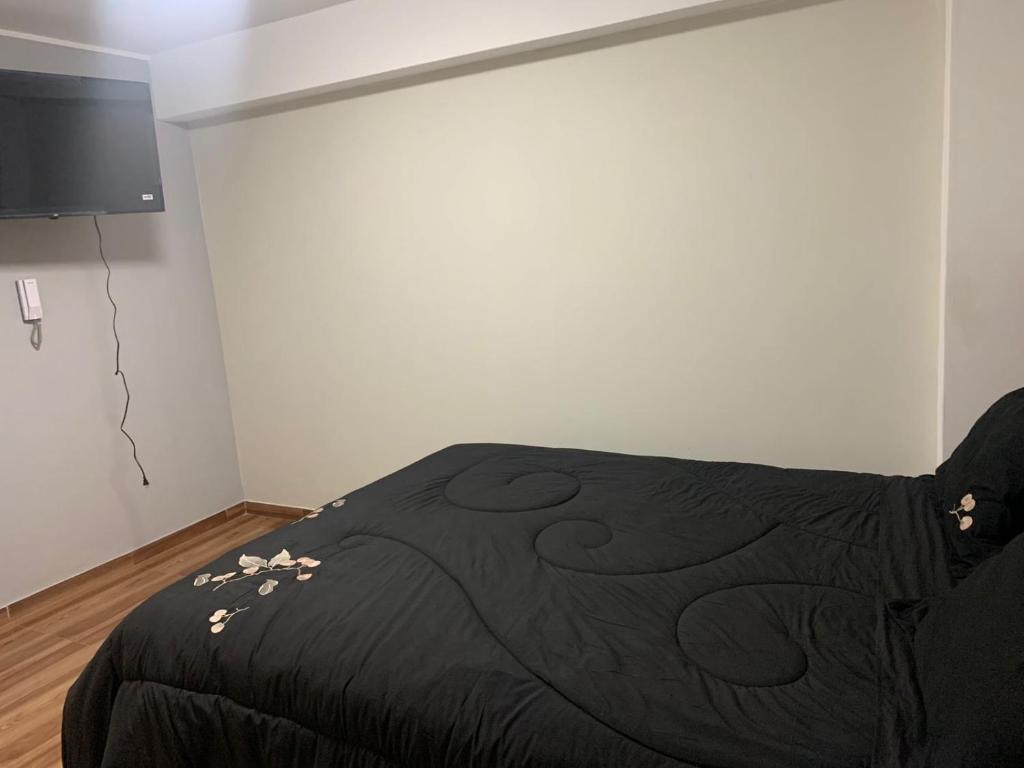 a bedroom with a black bed with flowers on it at Hotel Huancayo - El Toro Wanka in San Antonio
