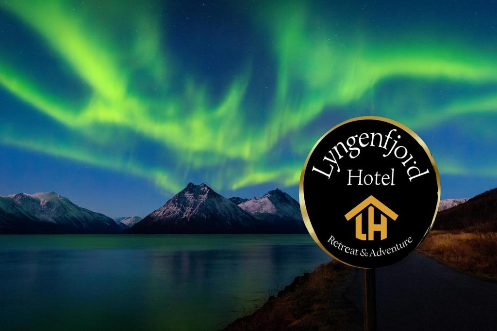 Un cartel frente a una vista de la aurora boreal. en Lyngenfjord Hotel, en Skibotn