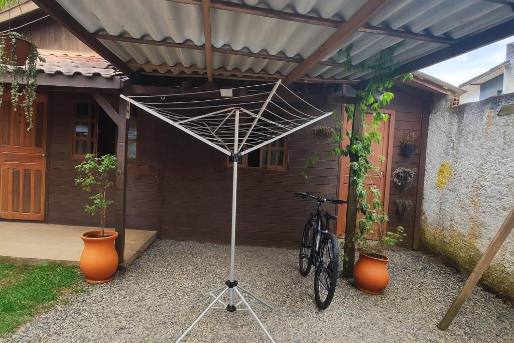 een fiets staat geparkeerd onder een metalen paraplu bij Casa Maria do Mar in Florianópolis
