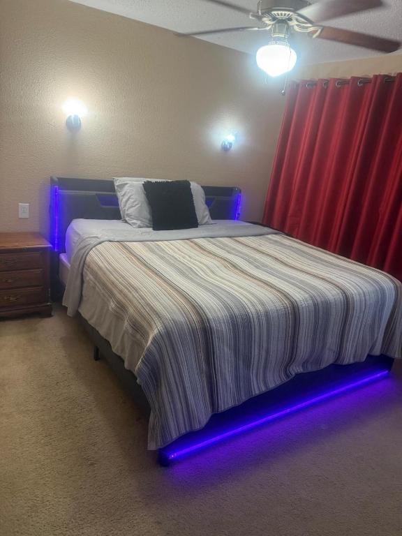 a bedroom with a bed with a blue led lighting at Comfort Stays Relax in a Cozy King Bedroom in Justin