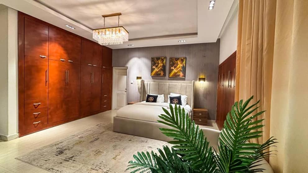 a bedroom with a bed and a plant in it at Sujimoto Residences MacDonald in Lagos