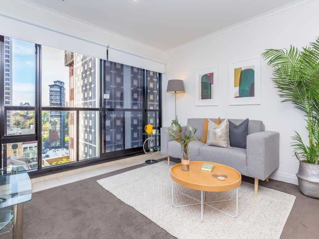 a living room with a couch and a table at Cozy City Apt with Pool, Gym & View by Zodiak Stays in Auckland