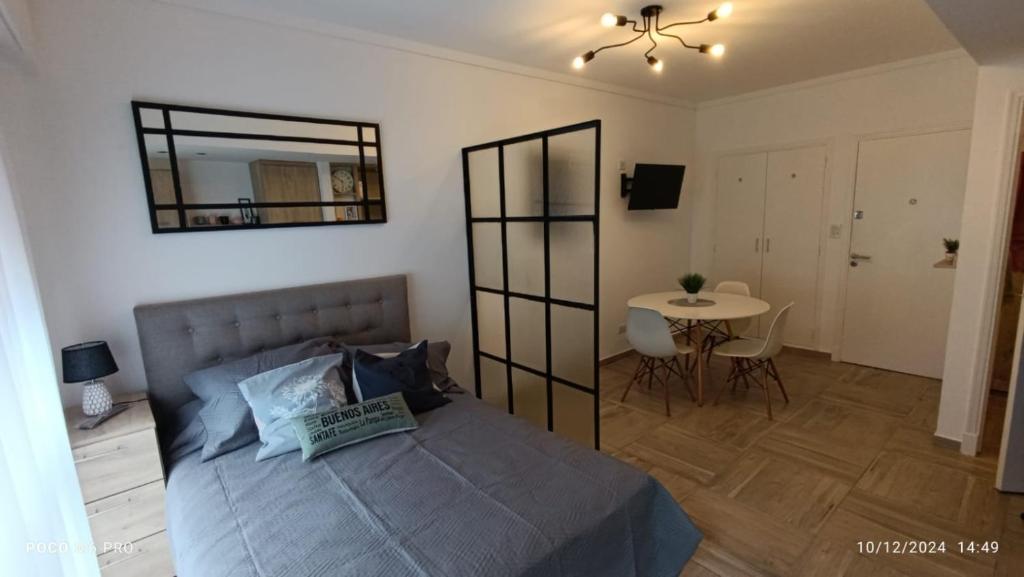 ein Schlafzimmer mit einem Bett, einem Tisch und einem Spiegel in der Unterkunft Entre Ríos y Brown in Mar del Plata