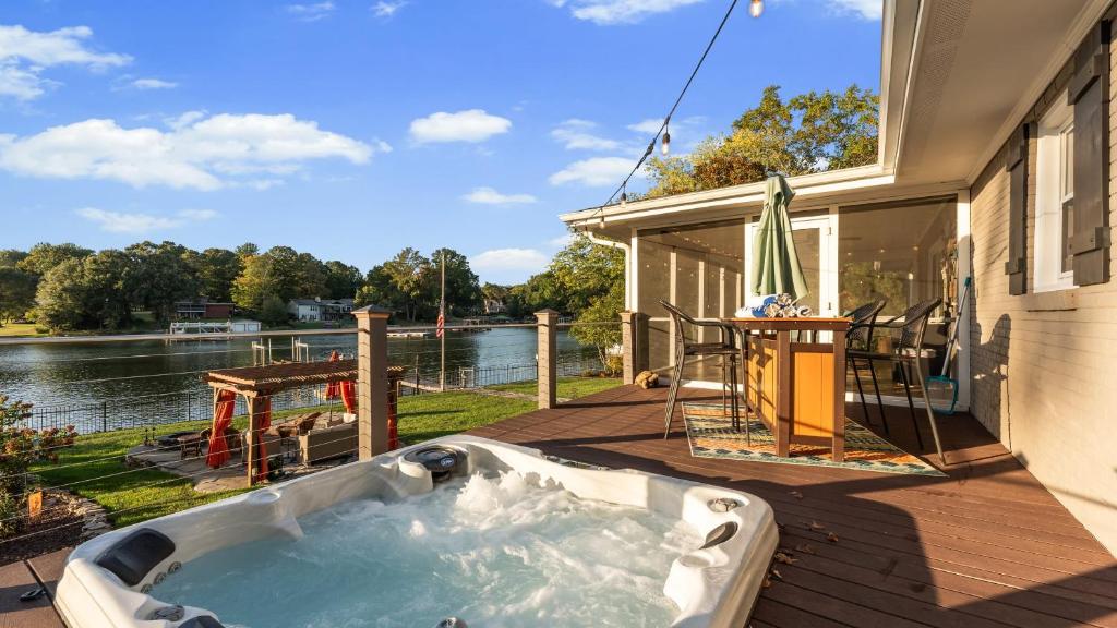 une baignoire jacuzzi sur la terrasse d'une maison dans l'établissement Dock Hot Tub Kayaks on Lake Norman Lakeside Gem by AvantStay, à Westport