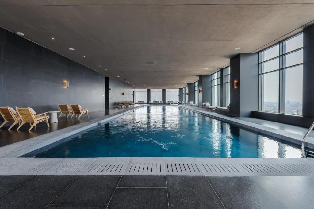 a large swimming pool in a building with windows at Be Grand by Wynwood House in Mexico City