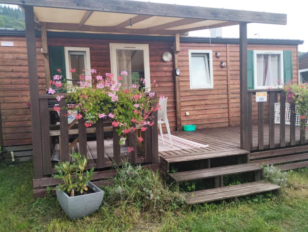 a cabin with a deck with flowers on it at Mobilhomme munster in Munster