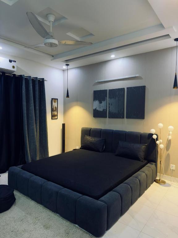 a bedroom with a large blue bed in a room at The Cozy Nest in Lahore