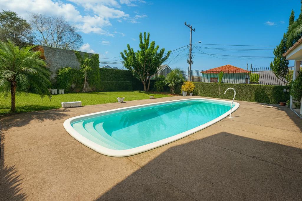 a large swimming pool in a yard at Casa com Piscina Gigante, Lareira e Churrasqueira in Campo Bom