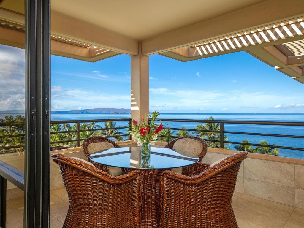 Una mesa en un balcón con vista al mar. en Polo Beach Club 801, en Wailea