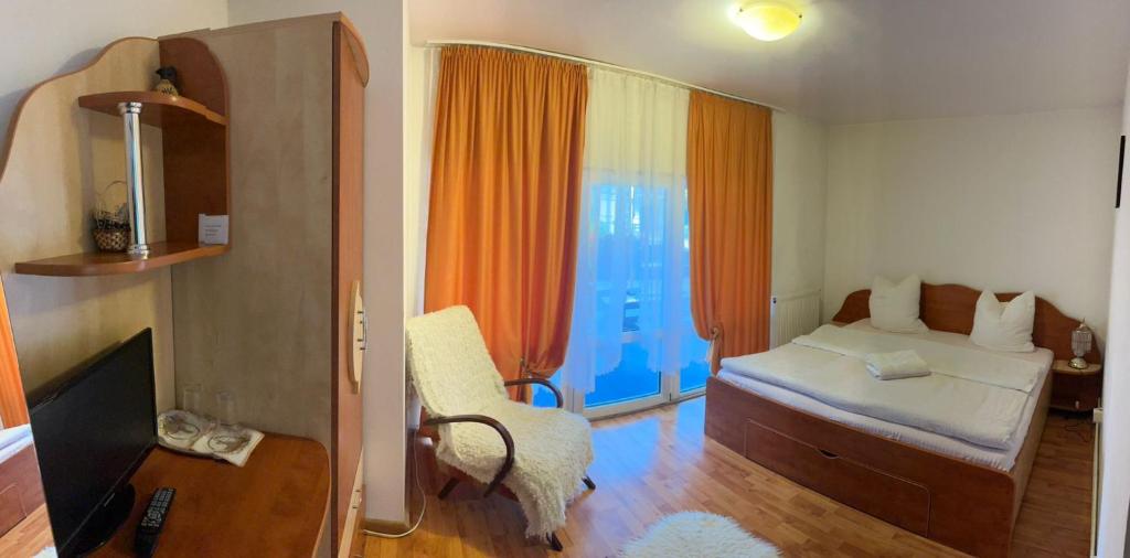 una piccola camera da letto con un letto e una sedia di Bran Moieciu Escape by BuySellRent a Moieciu de Jos