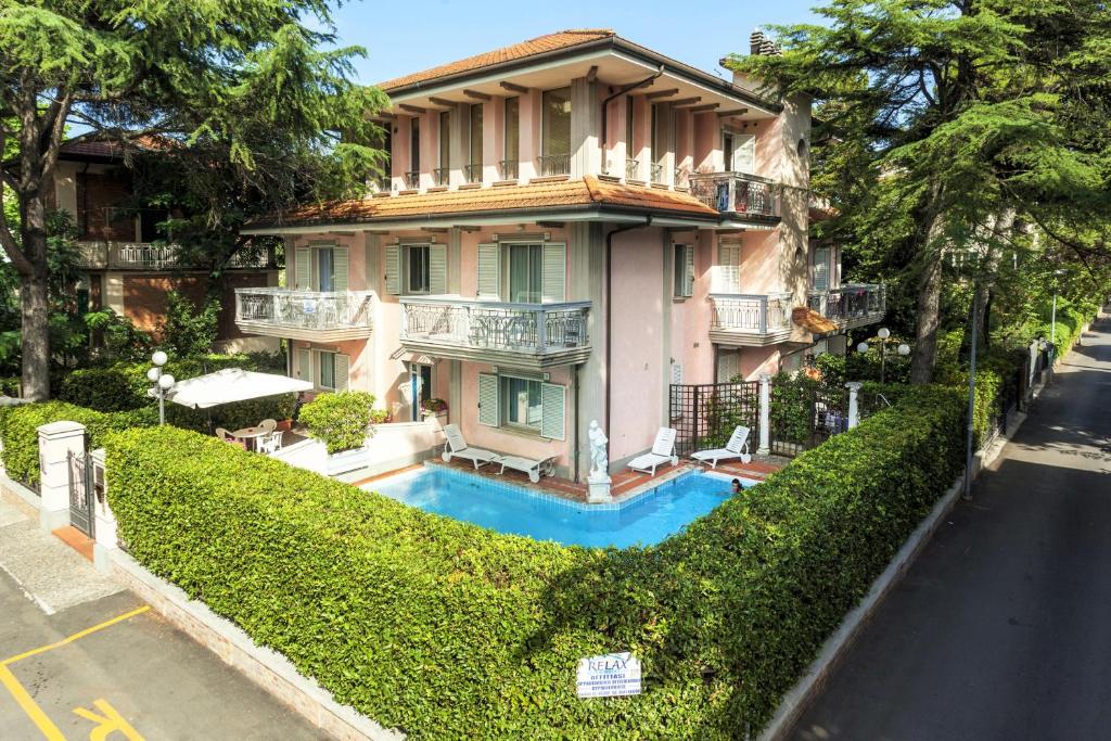 a house with a swimming pool in front of a street at Residenza Villa Lidia in Riccione