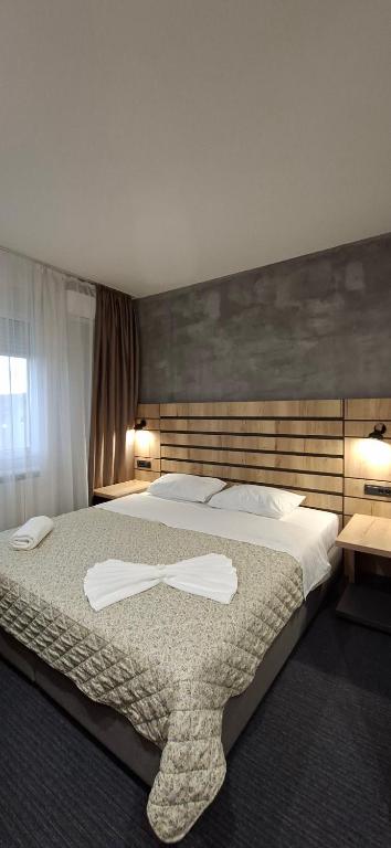 a bedroom with a large bed with two towels on it at Sremski Kutak in Stara Pazova