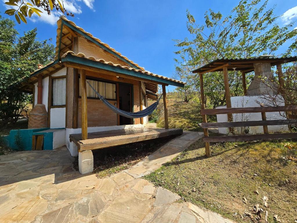 a small shack with a hammock in front of it at Chalezinho Mata Virgem - perto do centro e cachoeiras, cozinha completa e churrasqueira in Carrancas