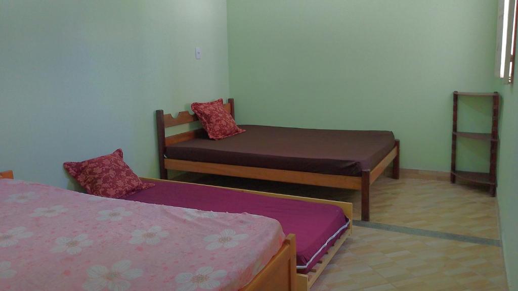 ein kleines Zimmer mit 2 Betten und einem Stuhl in der Unterkunft Casa praia de Guriri temporada in Guriri