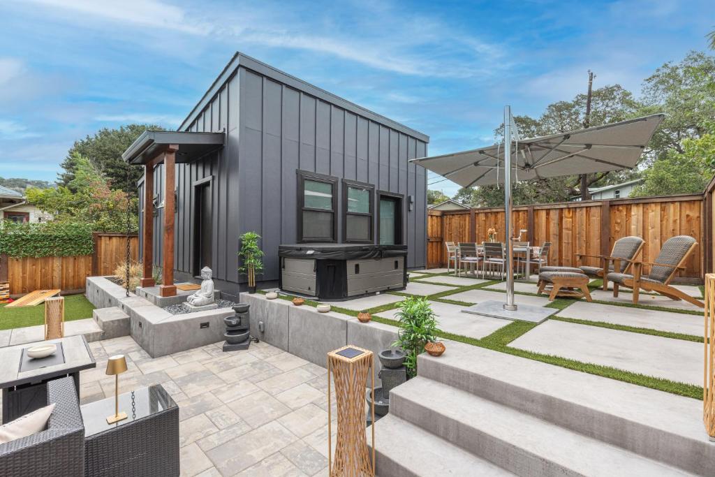 einen Hinterhof mit einem schwarzen Haus mit einer Terrasse in der Unterkunft Uncork & Unwind I Sip, Soak & Stroll Downtown Napa in Napa
