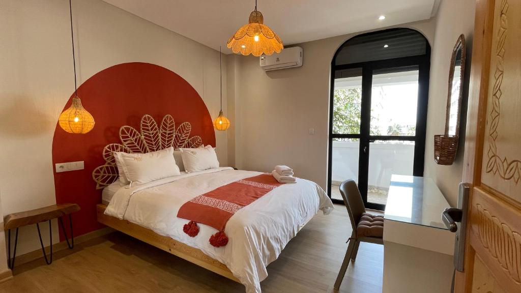 a bedroom with a large bed with a red headboard at Petit Bali 4-5px in Agadir