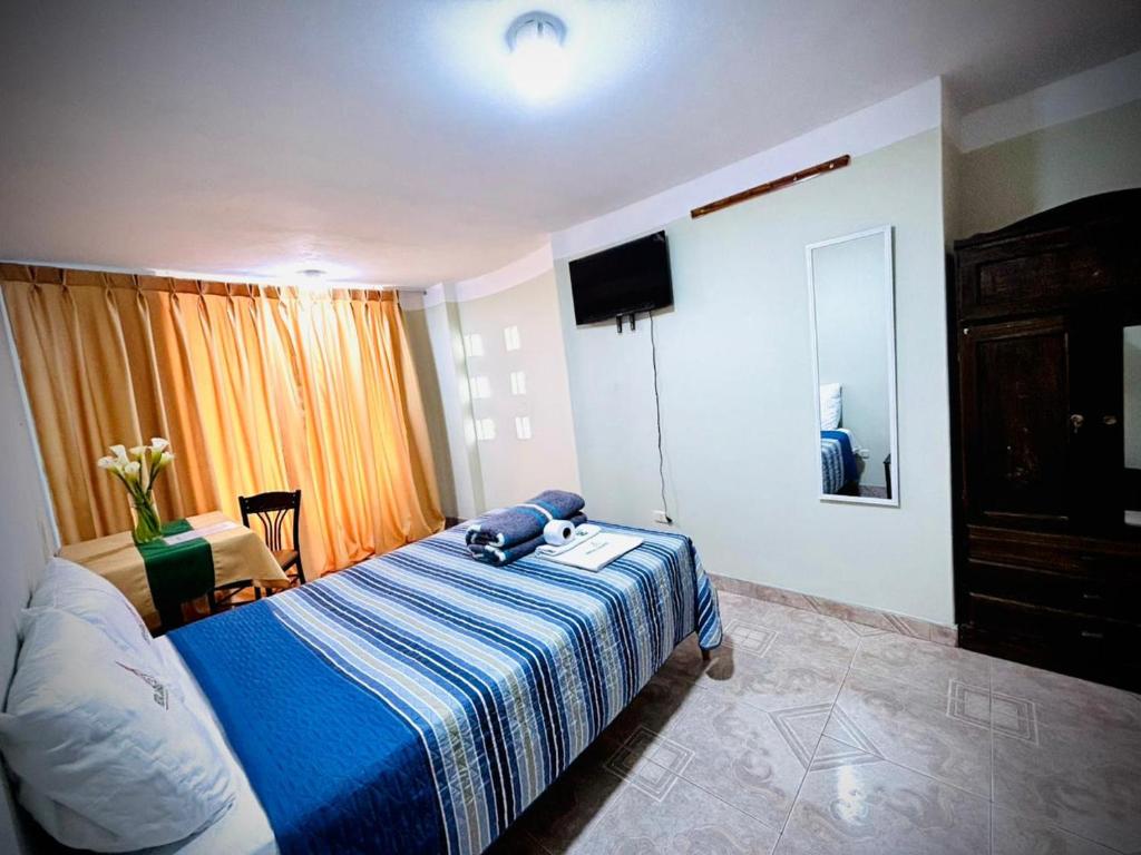 Hospedaje Carrasco Cajamarca في كاخاماركا: غرفة نوم بسرير وبطانية زرقاء وبيضاء