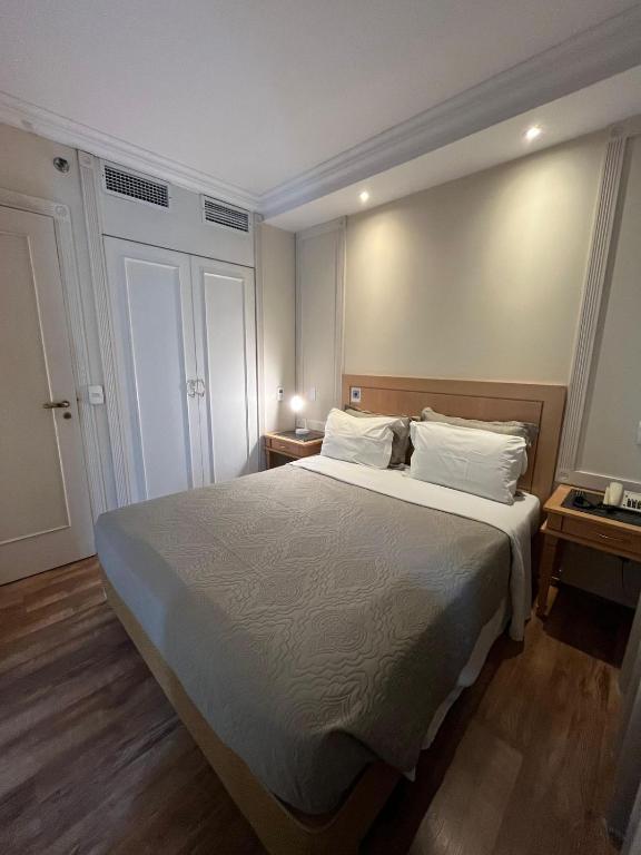 サンパウロにあるHotel Jardins Univer Pamplona com garagem 1808の大きなベッドと2つのナイトスタンドを備えた寝室