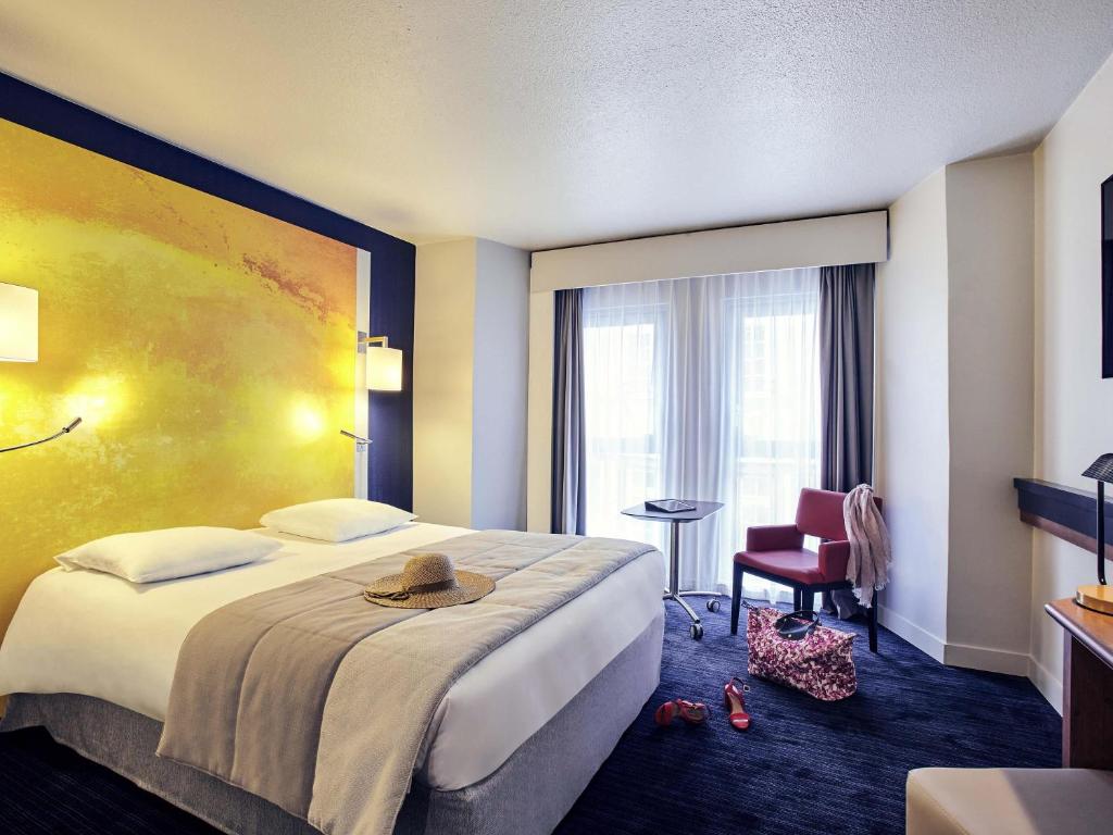 a hotel room with a bed with a hat on it at Mercure Rouen Centre Cathédrale in Rouen