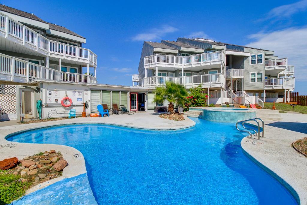 - une piscine en face d'un immeuble dans l'établissement Steps to Shore Condo with Balcony in Port Aransas, à Mustang Beach